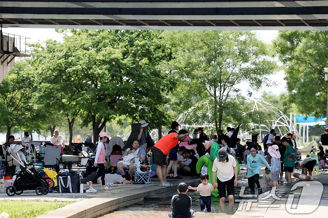 6.3지방선거 투표일인 3일 낮 기온이 30도를 넘으며 무더운 날씨를 보이자 서울 영등포구 여의도한강공원을 찾은 시민들이 물놀이를 하며 더위를 식히고 있다. 2026.6.3 ⓒ 뉴스1 이광호 기자
