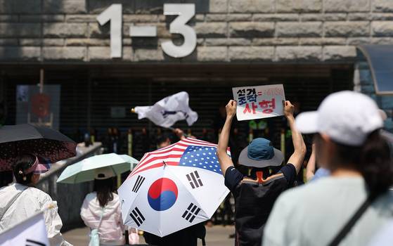 6·3 지방선거 투표용지 부족 사태를 규탄하며 재선거를 요구하는 '잠실 개표소 봉쇄 시위'가 이어진 지난 9일 서울 송파구 올림픽공원 핸드볼경기장에서 시민들이 구호를 외치고 있는 모습. 〈사진=연합뉴스〉