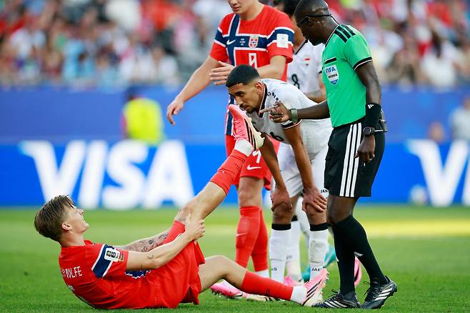 17일 노르웨이 다비드 묄레르 볼페가 이라크에 2-1로 앞선 후반 20분 근육 경련이 일어났다며 주저앉자 심판이 다가가 확인하고 있다. 뵐페는 금방 일어났고, 8분 정도 더 뛰고 교체됐다. /로이터 연합뉴스