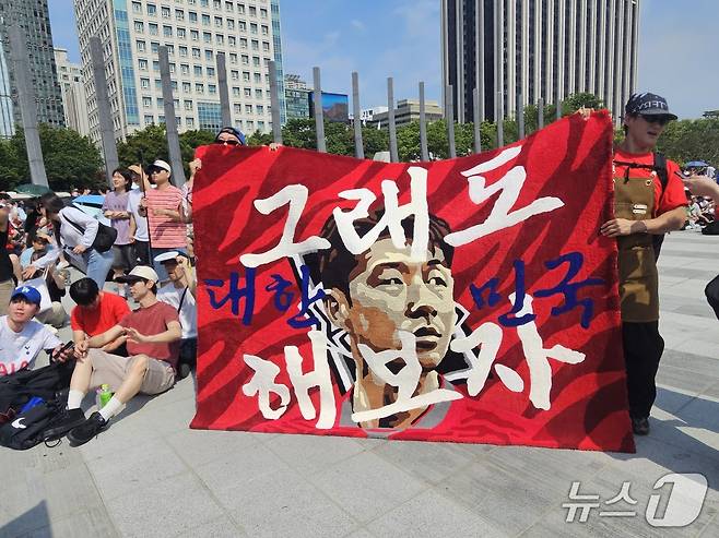 손흥민 선수 얼굴에 '그래도 대한민국 해보자'라고 적힌 대형 러그를 만들어 온 서윗(작가명·36·남) 씨의 모습. 2026.6.19 ⓒ 뉴스1 한민아 기자
