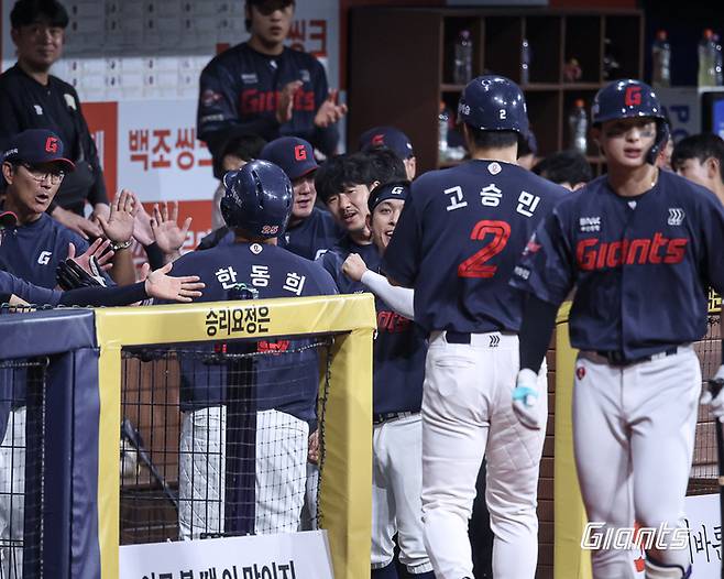 롯데 한동희(왼쪽)와 고승민이 19일 서울 고척스카이돔에서 열린 2026 KBO리그 키움전에서 득점에 성공한 뒤 더그아웃에서 동료들과 하이파이브를 하고 있다. 사진 | 롯데 자이언츠