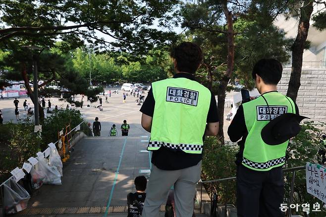 제9회 전국동시지방선거 투표용지 부족 사태에 항의하는 개표소 봉쇄 시위. 16일 오전 8시 송파구 올림픽 핸드볼경기장 앞에서 시민들이 “부정선거 재선거. 당일선거 수개표” 의 구호를 외치는 모습을 경찰이 지켜보고 있다. 변영욱 기자 cut@donga.com