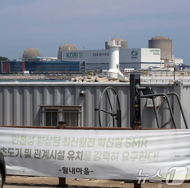 지난 18일 부산 기장군 장안읍 월내방파제 인근에 내걸린 SMR 기장군 유치를 바라는 내용의 현수막 뒤로 고리1, 2, 3, 4호기가 보이고 있다.ⓒ 뉴스1 윤일지 기자