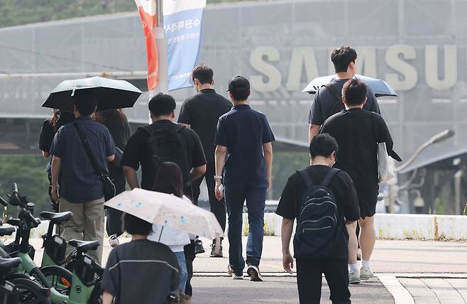 23일 경기 수원시 영통구 삼성전자 수원캠퍼스에서 디바이스경험(DX)부문 직원들이 반도체(DS)부문과의 성과급 격차에 항의하기 위해 검은 옷을 입고 출근하고 있다. 뉴스1