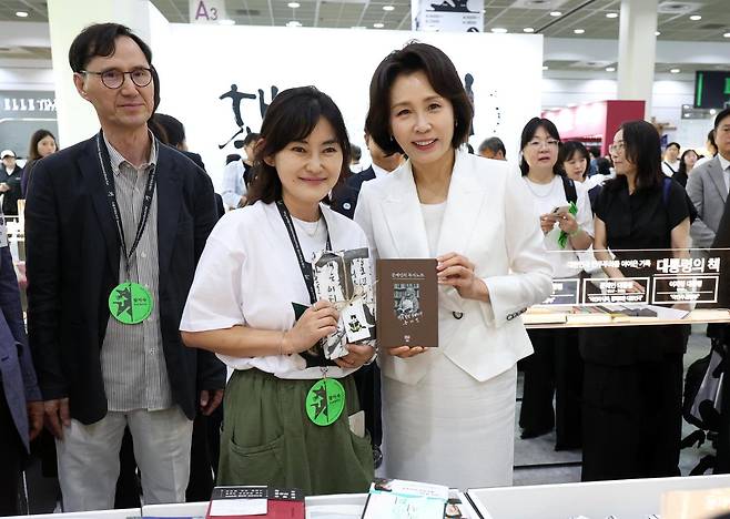 김혜경 여사가 24일 서울 강남구 코엑스에서 열린 2026 서울국제도서전 개막식에서 문재인 전 대통령의 저서 '문재인의 독서노트'를 들고 기념 촬영을 하고 있다. 뉴스1