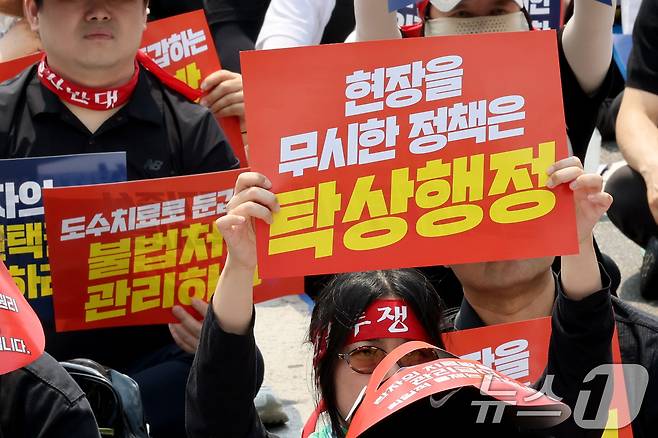 도수치료 관리급여 전환을 앞두고 28일 서울 종로구 경복궁 인근에서 열린 도수치료 생존권 수호 전국 물리치료사 총궐기대회에서 참가자들이 손피켓을 들고 '현실 무시 획일적 관리급여, 환자 중심 전면 재설계' 등을 촉구하고 있다. 2026.6.28 ⓒ 뉴스1 이광호 기자