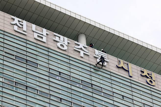 전남광주통합특별시 출범을 하루 앞둔 30일 광주 서구 광주광역시청 외벽에서 작업자들이 전남광주통합특별시 간판을 설치하고 있다. 연합뉴스