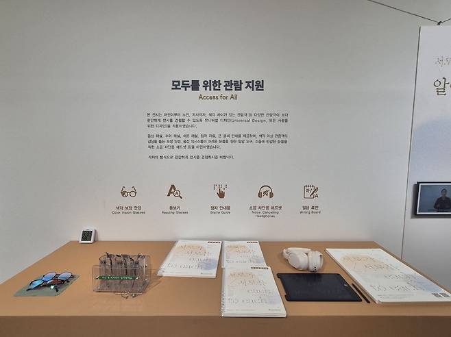 서울 은평구 한국기독교역사문화관에서 열린 배리어 프리 기획전 ‘서로가 서로를’에 제공되는 안내 자료들. 색각 보정 안경과 필담 도구, 소음 차단 헤드셋, 돋보기 등이 보인다.