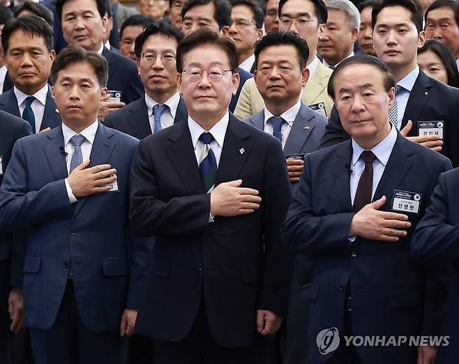 국민의례하는 이재명 대통령 (광주=연합뉴스) 한상균 기자 = 이재명 대통령이 30일 광주 김대중컨벤션센터에서 열린 서남권 첨단산업 발전비전 국민보고회에서 국민의례를 하고 있다.
왼쪽부터 곽노정 SK하이닉스 대표, 이재명 대통령, 전영현 삼성전자 부회장. 2026.6.30 xyz@yna.co.kr