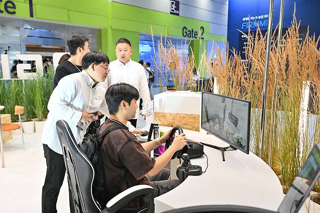2026 농식품 테크 스타트업 창업박람회(AFPRO 2026)가 오는 15일부터 17일까지 사흘간 서울 코엑스 3층 C홀에서 열린다. 사진은 작년 행사장에서 한 관람객이 가상공간에서 트랙터로 농작업을 하고 있는 모습.