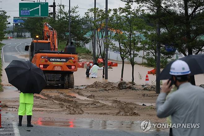 흙더미와 물바다가 된 출근길 도로 (세종=연합뉴스) 김주성 기자 = 폭우가 내린 9일 세종시 한별동 BRT 교차로 부근 도로가 공사장에서 흘러내린 토사에 덮여 침수되자 작업자들이 복구작업을 벌이고 있다. 2026.7.9 utzza@yna.co.kr