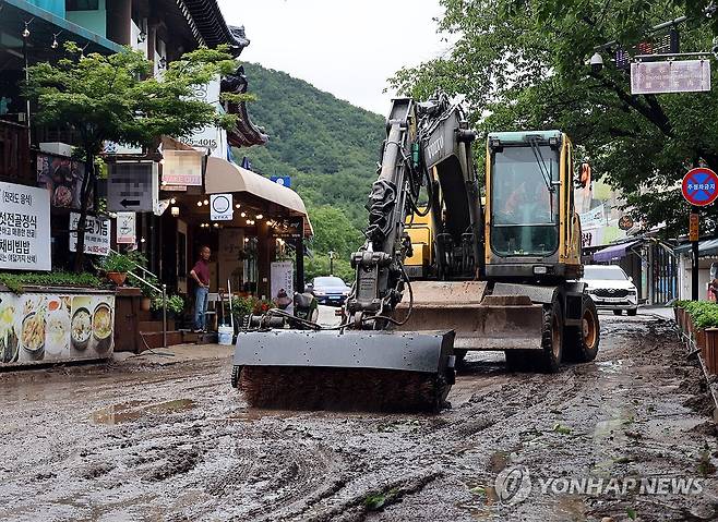 폭우가 남긴 흔적 (대전=연합뉴스) 이주형 기자 = 폭우가 내린 9일 충남 공주시 반포면 계룡산 동학사 밑 식당·상점가 일대가 침수된 가운데, 도로에 쌓인 토사를 걷어내는 복구작업이 한창이다. 2026.7.9 coolee@yna.co.kr