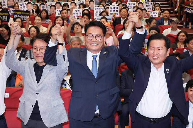 김민석(왼쪽부터)·송영길·정청래 더불어민주당 당대표 후보가 12일 서울 여의도 국회 의원회관에서 열린 전국자치분권민주지도자회의 당대표 후보 정견 발표에서 손을 잡고 기념 촬영하고 있다. 뉴스1