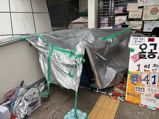 15일 오전 7시께 서울 송파구 올림픽공원 핸드볼경기장 주변 임시 텐트. 밤사이 비가 내리자 비닐로 간이 지붕을 만들었다. 윤승현 수습기자