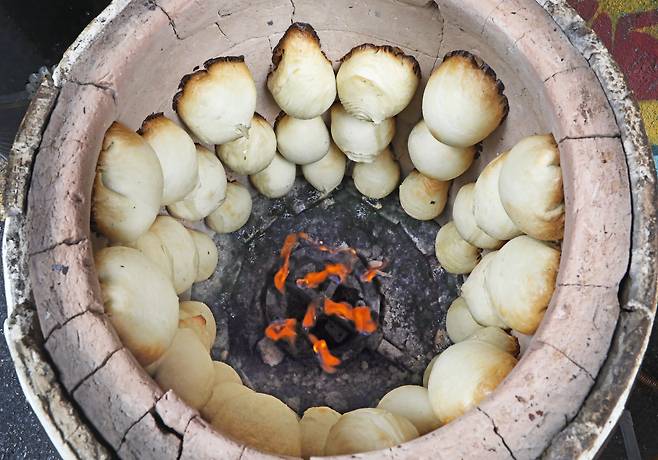 Somsa (meat pastries) are baked inside a clay oven. PARK SANG-MOON