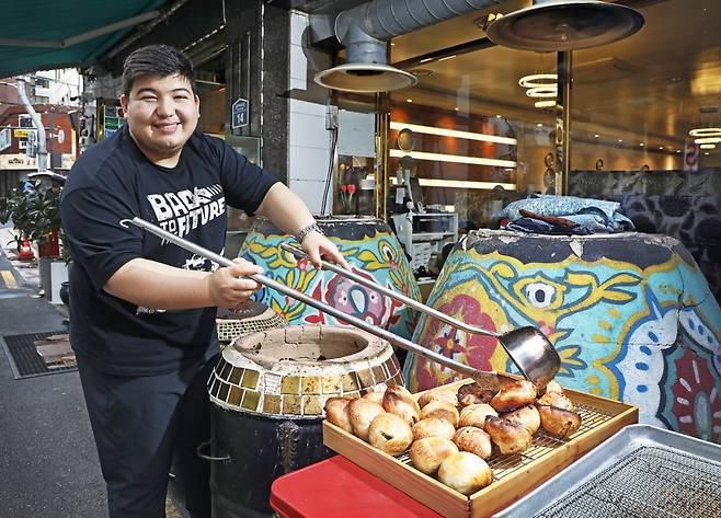 Amonov Shohjahon, owner of the Uzbek restaurant Star Samarkand, places freshly baked somsa (meat pastries) on a tray. PARK SANG-MOON