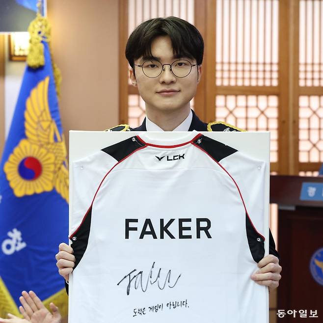 프로게이머 ‘페이커’ 이상혁이 22일 서울 서대문구 경찰청에서 명예경찰 및 사이버도박 예방 홍보대사로 위촉된 가운데 도박 중독을 극복한 청소년들에게 전달할 유니폼에 사인을 한 뒤 들어 보이고 있다.
김재명 기자 base@donga.com