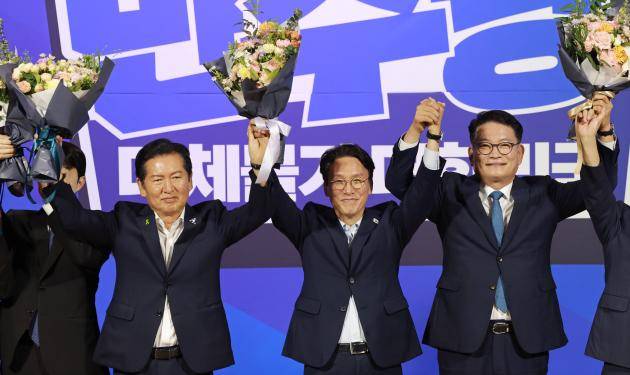 더불어민주당 당 대표 본경선에 진출한 정청래(왼쪽부터), 김민석, 송영길 후보가 23일 국회 의원회관에서 당 대표·최고위원 예비경선 결과 발표 뒤 단상에 올라 기념촬영을 하고 있다. /연합뉴스