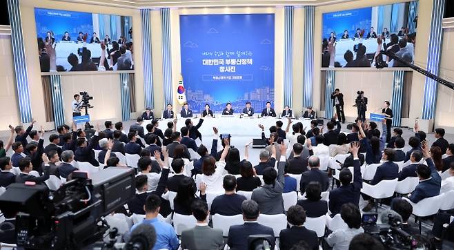 청약보다 어려운 발언권 경쟁 - 이재명 대통령 주재로 23일 서울 여의도 KBS 별관에서 열린 ‘부동산정책 국민 대토론회’에서 장내를 가득 채운 참석자들이 발언권을 얻기 위해 손을 들고 있다. 연합뉴스