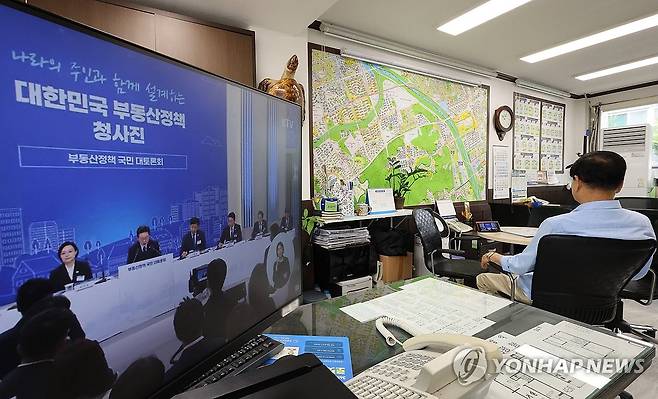 부동산정책 국민 대토론회 중계방송 (서울=연합뉴스) 이진욱 기자 = 23일 서울 강남구 한 부동산 중개업소에서 관계자가 '부동산정책 국민 대토론회' 중계방송을 보고 있다. 2026.7.23 cityboy@yna.co.kr