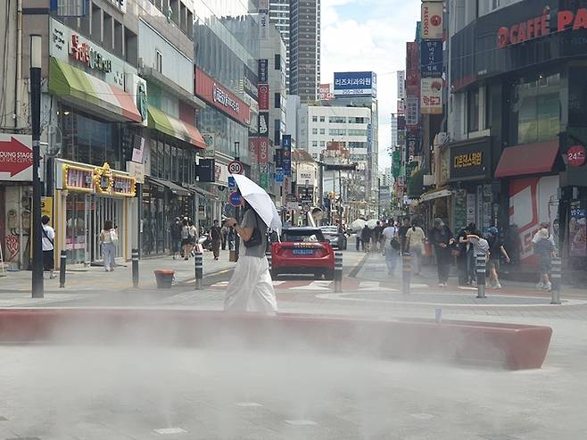 폭염중대경보가 내려진 26일 오후 대구 중구 동성로 일대에서 시민들이 쿨링포그가 뿜어내는 물안개를 맞으며 더위를 식히고 있다. 김민진 수습기자