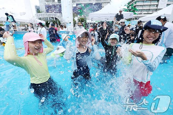 무더운 날씨를 보인 26일 오후 서울 종로구 광화문광장에 마련된 2026 서울썸머비치 수영장에서 시민들이 물놀이를 하며 즐거운 시간을 보내고 있다. 2026.7.26 ⓒ 뉴스1 김민지 기자