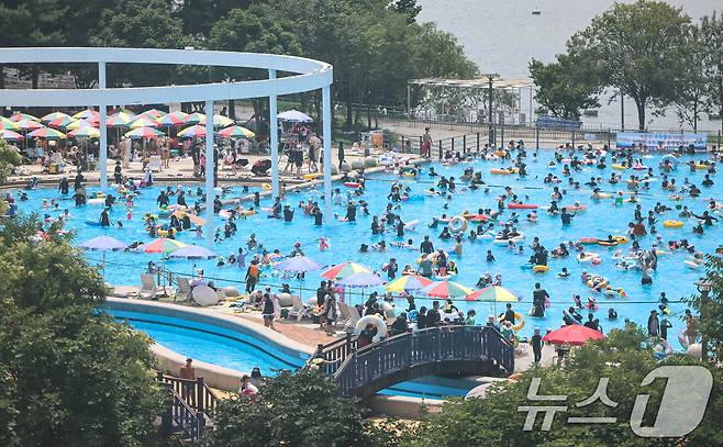 전국 대부분 지역에 폭염이 찾아온 26일 서울 광진구 뚝섬 한강공원 수영장을 찾은 시민들이 물놀이를 하며 더위를 식히고 있다. 2026.7.26 ⓒ 뉴스1 김도우 기자