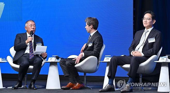 정의선 현대차그룹 회장이 지난 24일(현지시간) 미국 샌프란시스코 더 미드웨이에서 이재명 대통령이 참석한 '샌프란시스코 AI 서밋'에서 발언하고 있다. (왼쪽부터) 정의선 현대차그룹 회장, 샘 올트먼 오픈AI 최고경영자, 이재용 삼성전자 회장의 모습./연합뉴스