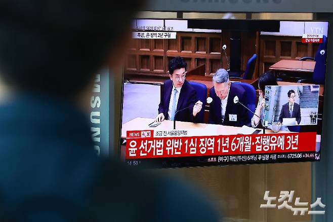 27일 서울 용산구 서울역 대합실에서 시민들이 윤석열 전 대통령의 공직선거법 위반 혐의 1심 선고 생중계를 보고 있다. 이날 법원은 윤석열에게 징역 1년 6개월에 집행유예 3년을 선고했다. 류영주 기자