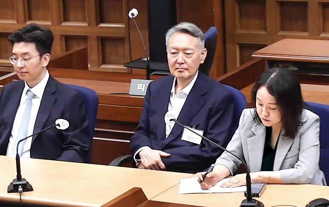 윤석열 전 대통령이 27일 서울중앙지법에서 열린 공직선거법 위반 혐의 1심 선고 공판에서 재판부의 주문을 듣고 있다. 재판부는 이날 윤 전 대통령에게 당선 무효형에 해당하는 징역 1년6개월에 집행유예 3년을 선고했다. 서울중앙지법 제공