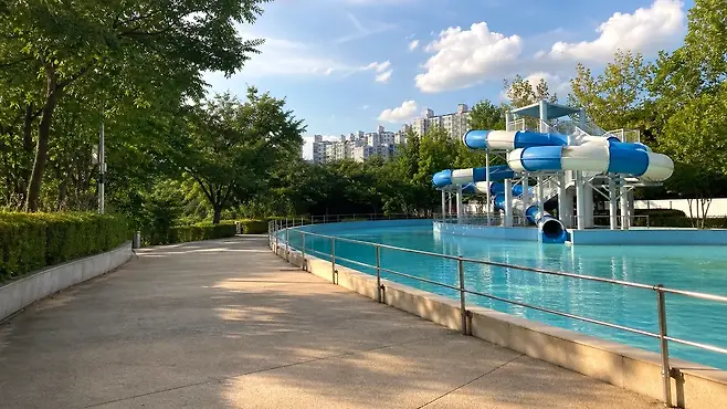 밝은 숲과 물길이 함께 보이는 여름 산길