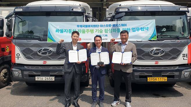 지난 28일 우체국물류지원단 본사에서 화물자동차 자율주행 기술 활성화를 위한 업무협약식이 진행된 가운데 (사진 왼쪽부터) 노제경 마스오토 부대표, 윤원근 우체국물류지원단 운송사업처장, 최양환 로지스퀘어 상무가 기념사진을 촬영하고 있다. (사진=마스오토)