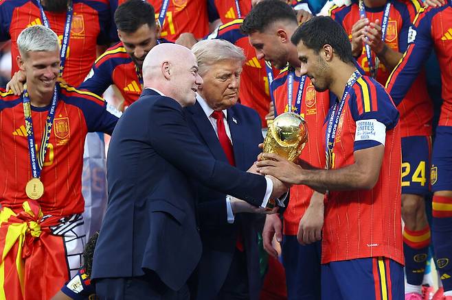 지난 19일(현지시각) 미국 뉴저지주 메트라이프 스타디움에서 열린 2026년 국제축구연맹(FIFA) 월드컵 결승전 스페인과 아르헨티나의 경기에서 스페인이 승리한 후 주장 로드리가 도널드 트럼프 미국 대통령과 잔니 인판티노 회장으로부터 월드컵 우승 트로피를 받고 있다. 로이터 연합뉴스