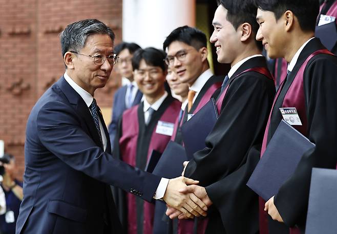 정성호 법무부 장관(왼쪽)이 3일 경기 과천시 법무부 청사에서 열린 신임검사 임관식에서 기념촬영을 마친 뒤 검사들과 악수하고 있다. 연합뉴스