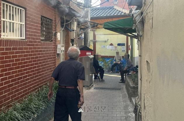 전국 대부분 지역에 폭염 경보가 내려진 2일 서울 창신동 쪽방촌 골목 초입에서 주민들이 냉각 안개 아래 그늘에 의자를 옮겨 놓고 무더위를 견디고 있다. 박다운 기자