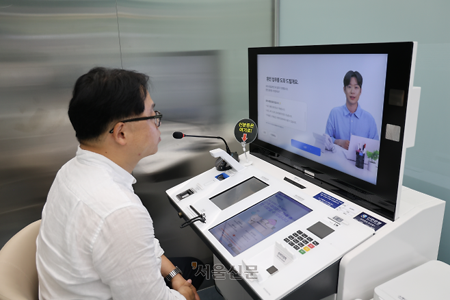 신한은행 인공지능(AI) 특화 점포인 서울 중구 서소문 지점에서 3일 직원이 고객에게 AI 창구 이용 방법을 안내하고 있다. AI 창구에서는 외환업무, 대출 상담, 상품 가입 등이 가능하다.