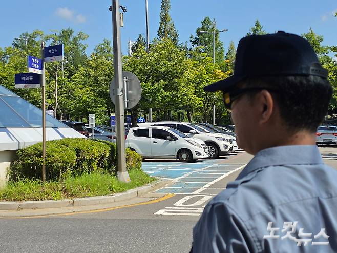 충남 천안시청 주차관리원이 내리쬐는 햇볕 아래 선글라스와 모자를 착용한 채 서있다. 박우경 기자