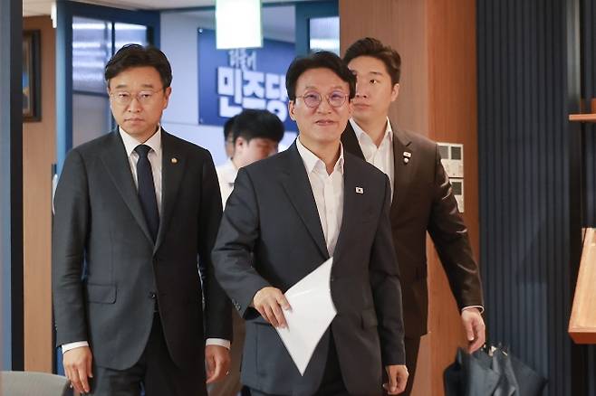 김민석 더불어민주당 당대표 후보가 지난달 15일 서울 여의도 더불어민주당 중앙당사에서 ‘당 4대 혁신안’을 발표하기 위해 당원존으로 입장하고 있다. 왼쪽부터 이용우 더불어민주당 의원, 김 후보, 김용만 더불어민주당 의원. 연합뉴스