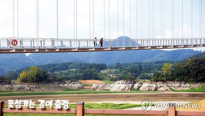 메마른 옥정호 위를 걷는 관광객들 (임실=연합뉴스) 김문경 기자 = 전북에 폭염이 이어진 6일 임실군 운암면 붕어섬 생태공원 흔들다리를 관광객들이 걷고 있다. 2026.8.6 door@yna.co.kr