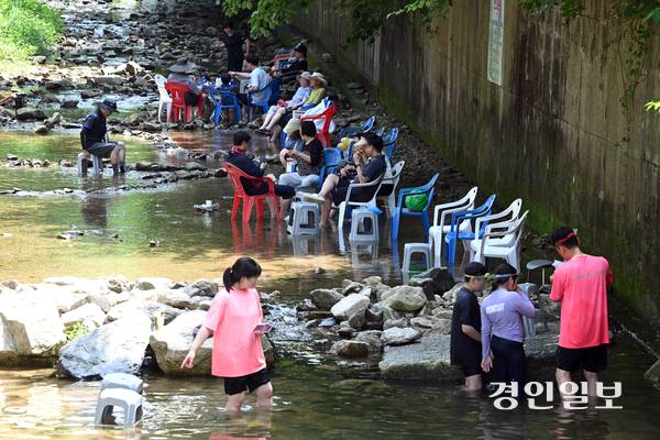 계곡 내 평상 설치 등 유속을 방해하는 시설물은 단속 대상이지만, 간이시설을 피서객이 설치한 경우 단속 대상에서 제외돼 설치 주체를 특정하기 어려운 점이 단속 사각지대로 악용되고 있다. 6일 용인시 처인구의 한 계곡에서 시민들이 간이 테이블과 의자를 이용하고 있다. 2026.8.6 /최은성기자 ces7198@kyeongin.com