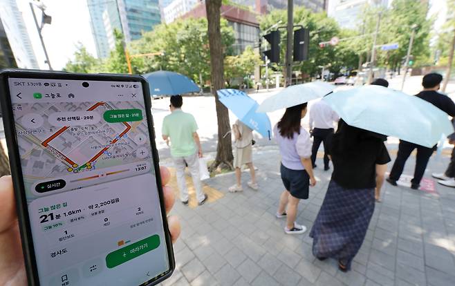 1주일 넘게 폭염이 계속된 6일 오후 1시쯤, 서울 영등포구 샛강역 부근 거리에서 한 시민이 휴대전화로 그늘을 찾아주는 앱 ‘그늘로’를 켜고 있다. ‘그늘로’는 시간대별로 달라지는 햇빛 방향에 따라 그늘이 있는 경로를 알려준다. /남강호 기자