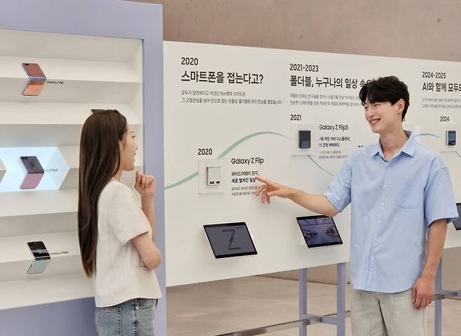 삼성전자 모델이 '폴더블 헤리티지'의 '갤럭시 폴드·플립 스토리' 섹션에서 역대 갤럭시 폴더블 라인업을 확인하는 모습ⓒ삼성전자