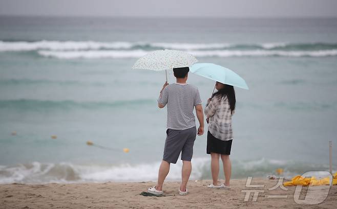 제주도 해상에 풍랑주의보가 내려지고, 비가 내리는 9일 오전 제주시 조천읍 함덕해수욕장에서 우산을 쓴 관광객들이 파도가 이는 바다를 바라보고 있다. 2026.8.9 ⓒ 뉴스1 강승남 기자