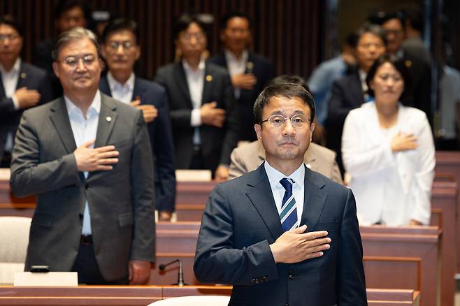 한병도 더불어민주당 당대표 직무대행 겸 원내대표를 비롯한 의원들이 지난달 30일 서울 여의도 국회에서 열린 의원총회에서 국민의례를 하고 있는 모습/뉴스1