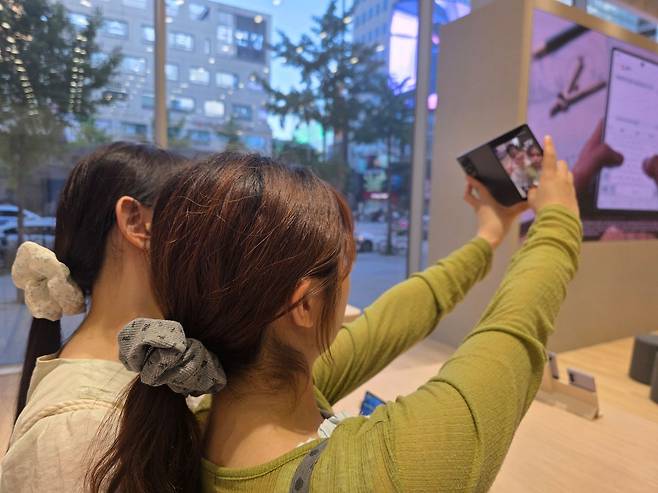 지난 11일 서울 마포구 삼성스토어 홍대에서 정서희(22), 지승연(22)씨가 새로 출시된 '갤럭시 Z폴드8'로 셀카를 찍고 있다. 이영근 기자