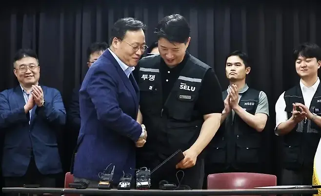 지난 5월 20일 삼성전자 노사가 2026년 임금협상 잠정합의안을 도출한 후 여명구 삼성전자 DS 피플팀장과 최승호 삼성그룹 초기업노동조합 삼성전자지부 위원장이 악수하고 있다. 그러나 메모리 부문에 비해 시스템 반도체 부문의 성과급이 상대적으로 적어 비메모리 부문 직원들의 반발이 커졌다. 사진=연합뉴스