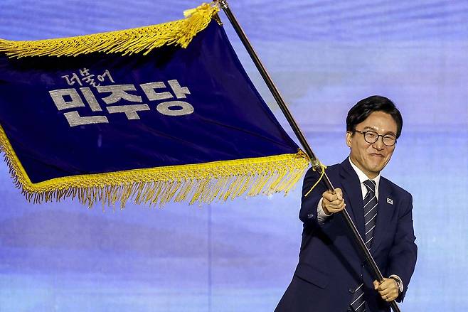 김민석 신임 더불어민주당 당대표가 17일 대전 유성구 대전컨벤션센터 제2전시장에서 열린 더불어민주당 제3차 정기전국당원대회에서 당기를 흔들고 있다. 뉴시스