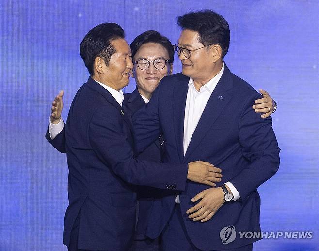 축하와 위로 그리고 격려로 경쟁 마무리 하는 민주당 당권 주자들 (대전=연합뉴스) 황광모 기자 = 17일 대전 컨벤션센터에서 열린 제3회 더불어민주당 정기 전국당원대회에서 더불어민주당 신임 당 대표로 선출된 김민석 전 총리(가운데)가 당 대표직을 놓고 경쟁을 벌였던 정청래 전 대표(왼쪽)과 송영길 의원이 서로 포옹하며 축하와 위로를 하고 있다. 2026.8.17 hkmpooh@yna.co.kr