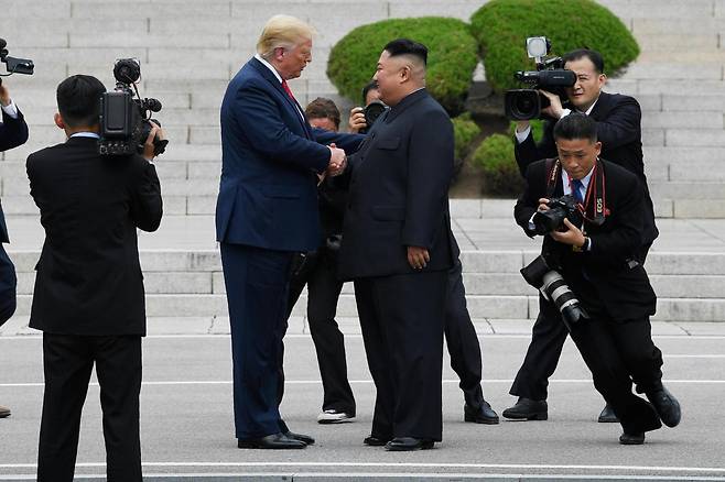 2019년 6월 30일 도널드 트럼프(가운데 왼쪽) 당시 미국 대통령이 한국 비무장지대(DMZ) 내 판문점에서 김정은 북한 국무위원장과 함께 북측 지역으로 걸어가 악수하고 있다. AP 연합뉴스