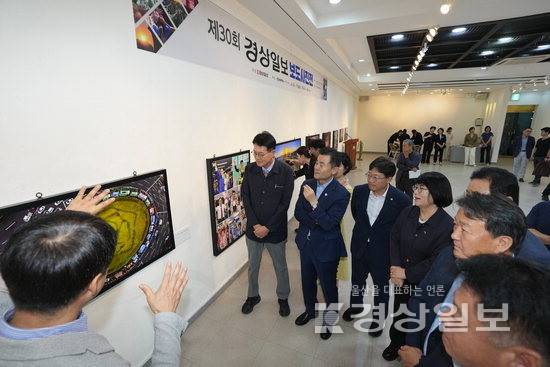 ▲ 19일 울산문화예술회관 제4전시장에서 열린 제30회 경상일보 보도사진전 개막식에서 엄주호 본사 대표이사와 이영해 울산시의장, 조용식 울산시교육감, 김영길 중구청장, 임현철 남구청장, 이순걸 울주군수, 참석인사들이 김동수 본사 사진영상부 부국장의 안내를 받으며 작품을 감상하고 있다.
